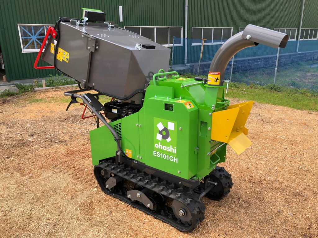 Photo of Ohashi ES101GH 4-inch compact tracked woodchipper static on some grass
