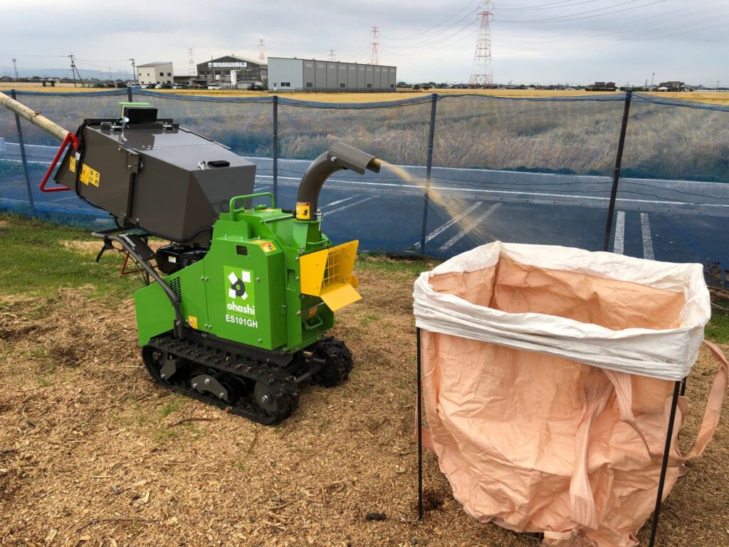 Photo on an Ohashi ES101GH 4-inch compact tracked woodchipper Chipping wood and shooting the chippings into a large bag

