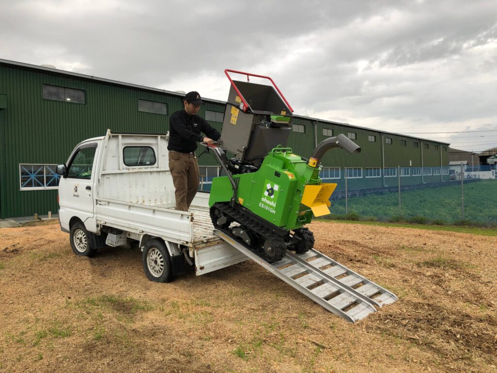 Photo of an Ohashi ES101GH 4-inch compact tracked woodchipper being loaded by ramp onto a small ohashi branded truck

