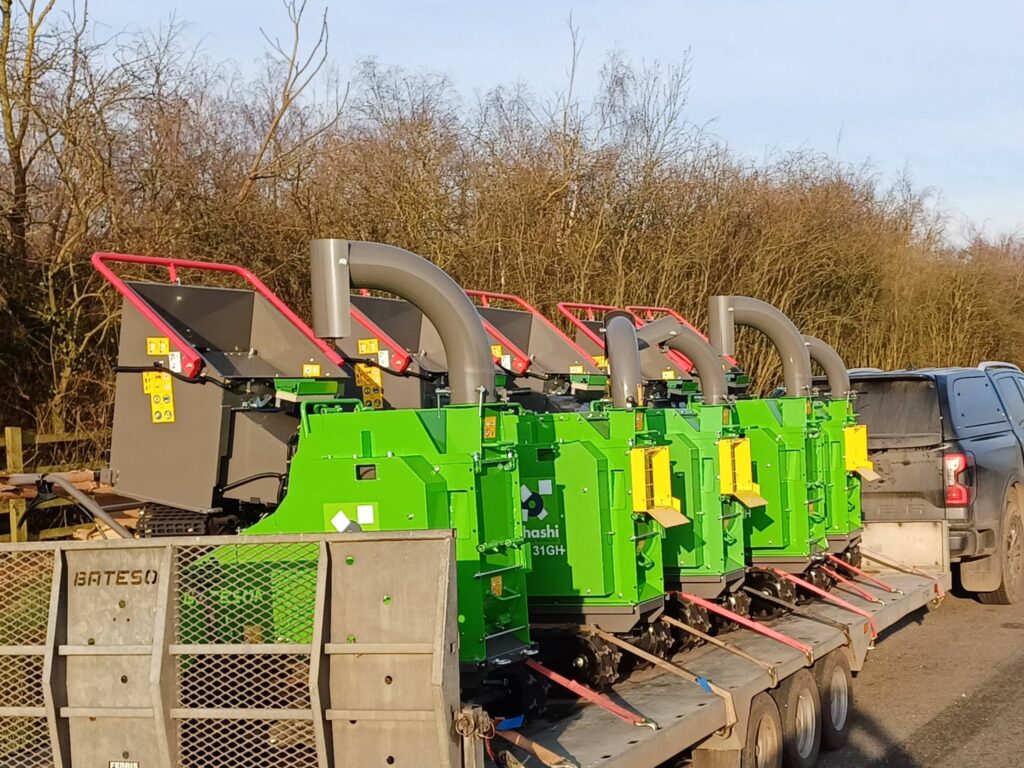 photo of 5 ES131GH 5-inch compact tracked woodchippers being towed on a trailer outside in the sun