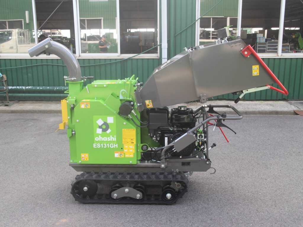 Side on photo of an Ohashi ES131GH 5-inch compact tracked woodchipper in a factory
