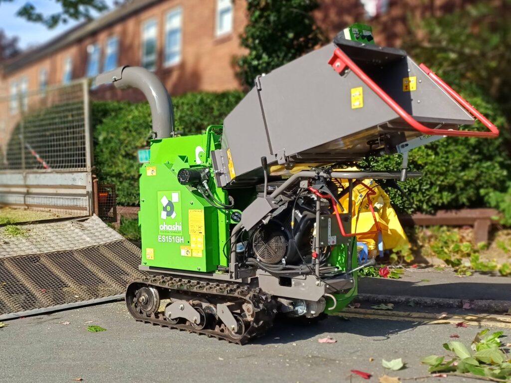 Photo of an Ohashi ES151GH 6-inch Compact tracked woodchipper on a street with a trailer nearby