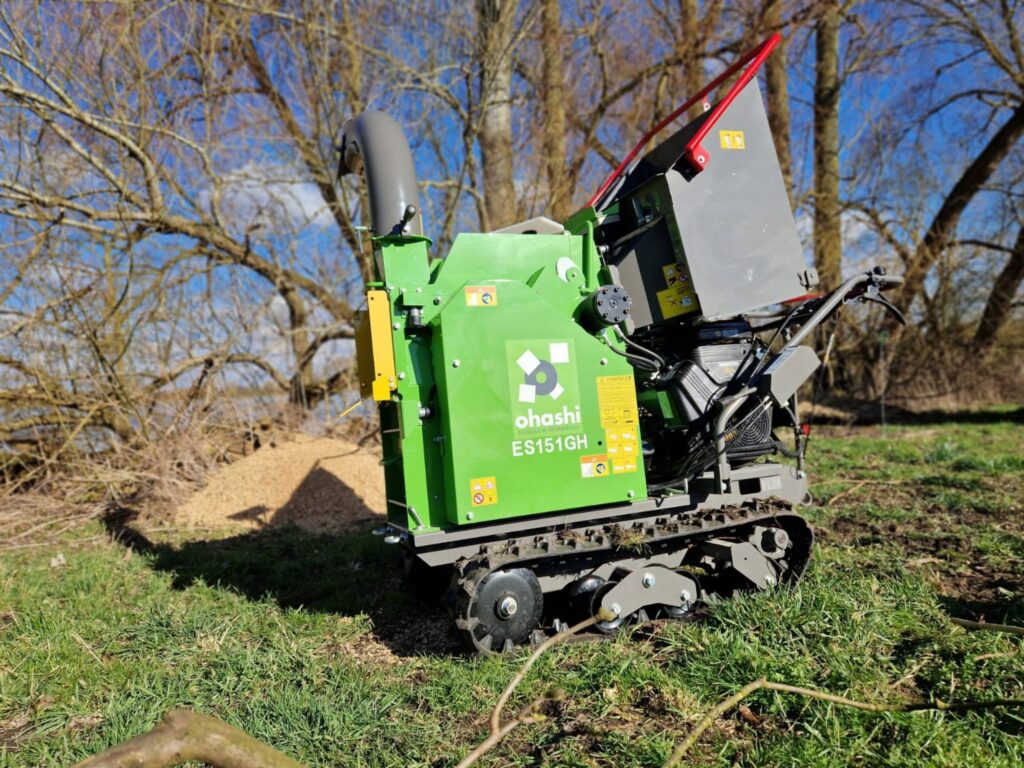 Photo of an Ohashi ES151GH 6-inch Compact tracked woodchipper, outside on grass chipping wood