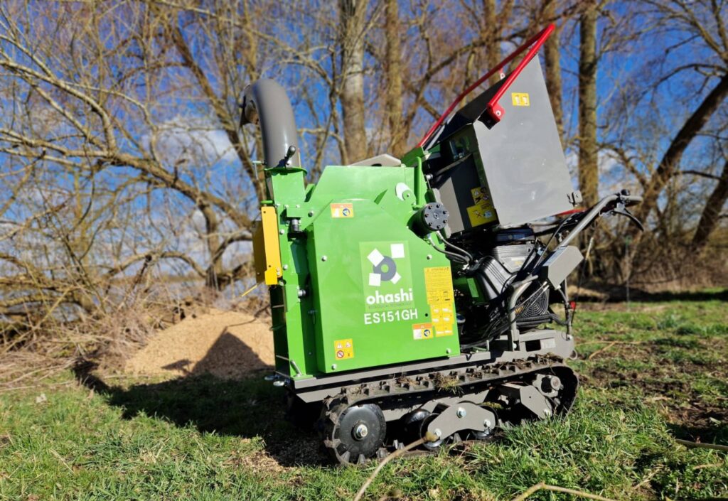 Photo of an Ohashi ES151GH 6-inch Compact tracked woodchipper, outside on grass chipping wood