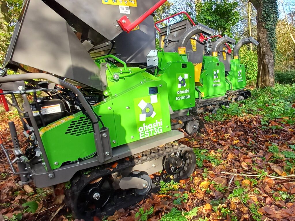 Photo of Ohashi ES73G 3-inch compact tracked woodchipper in the woods with other ohashi woodchipper models
